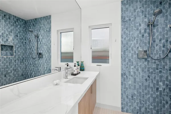 a bathroom with a double vanity sink mirror and shower