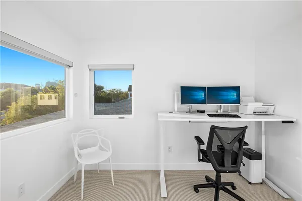 a view of a workspace with furniture and a window