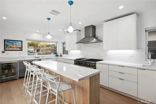a kitchen with stainless steel appliances granite countertop a sink a stove and a wooden floors