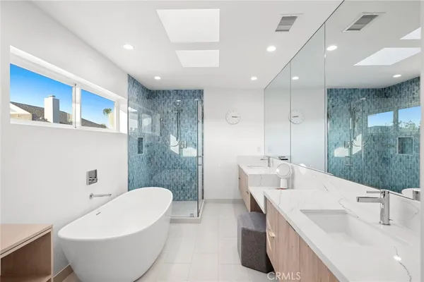 a bathroom with a white tub sink and mirror