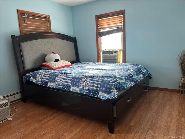 a bedroom with a bed wooden floor and window