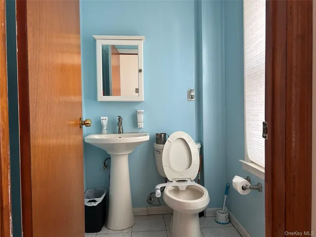 a bathroom with a toilet sink and mirror