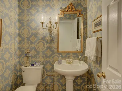 a bathroom with a sink and mirror with toilet