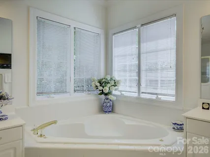 a white bath tub sitting in a bathroom next to a window