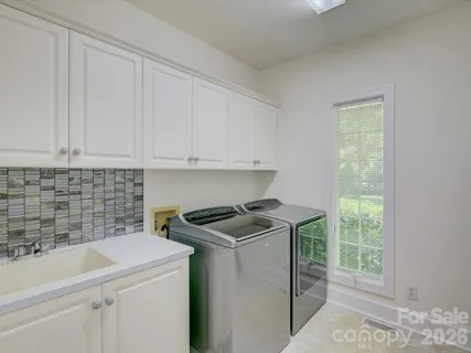 a utility room with sink dryer and washer