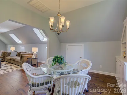 a view of a dining room with furniture a chandelier and wooden floor
