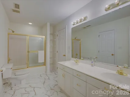 a bathroom with a double vanity sink mirror and shower