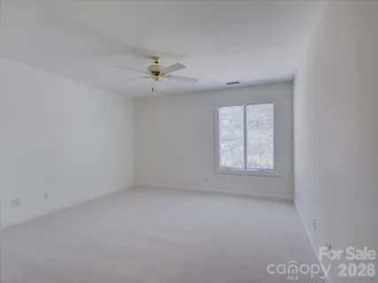an empty room with a window and a ceiling fan