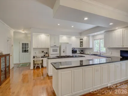 a large kitchen with kitchen island lots of counter space a sink and appliances