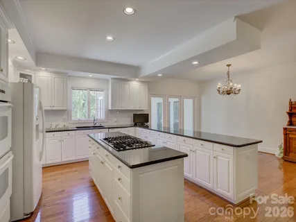 a kitchen with granite countertop a sink stove and refrigerator