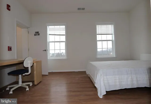 a bedroom with a bed chair and window