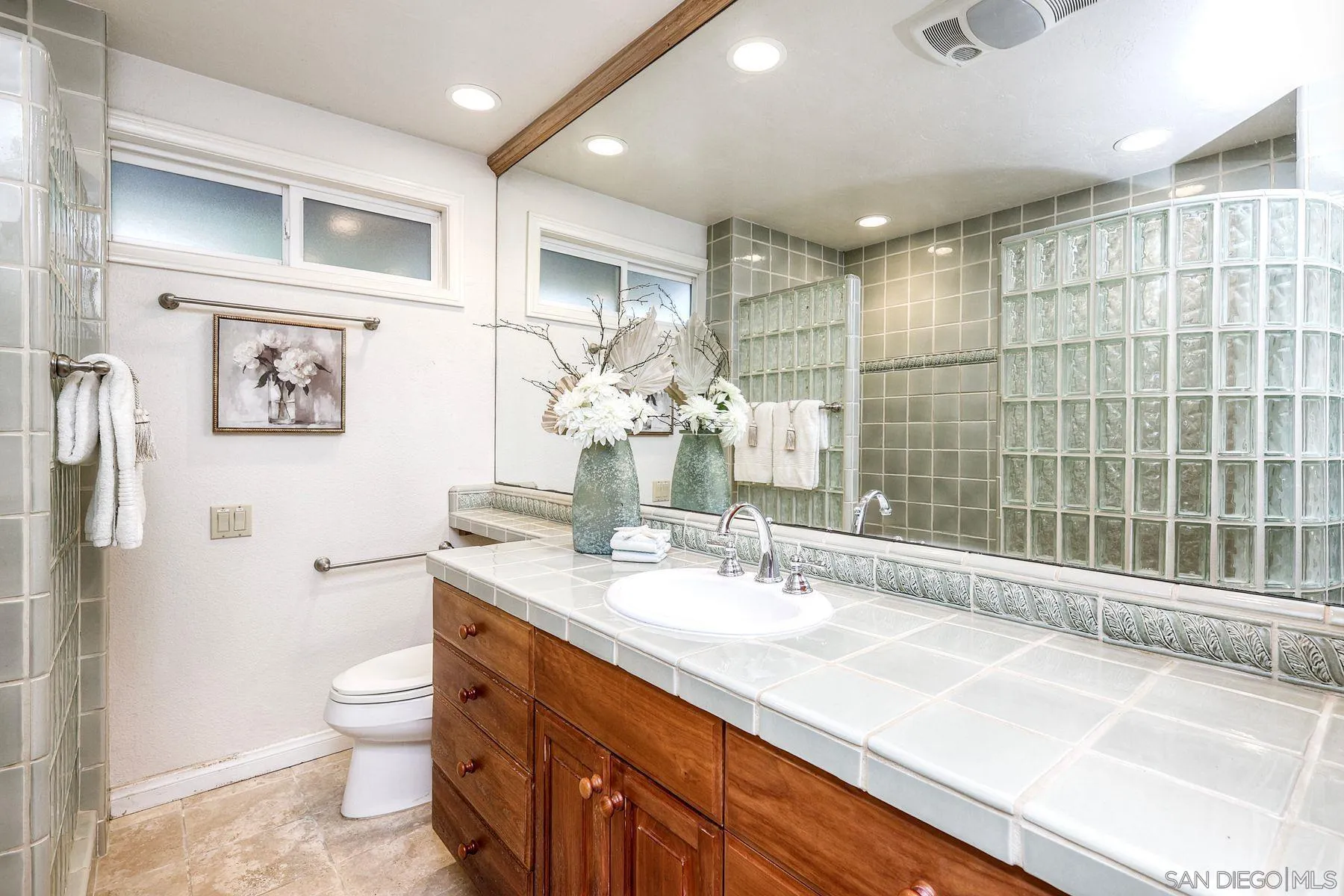 14036 Tierra Bonita Road Poway, CA 92064 - Photo 23 of 57 a bathroom with a double vanity sink toilet and shower