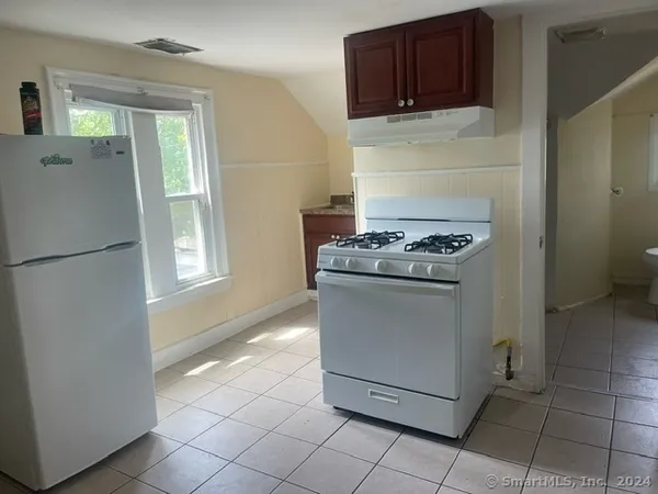 a kitchen with a stove top oven and cabinets
