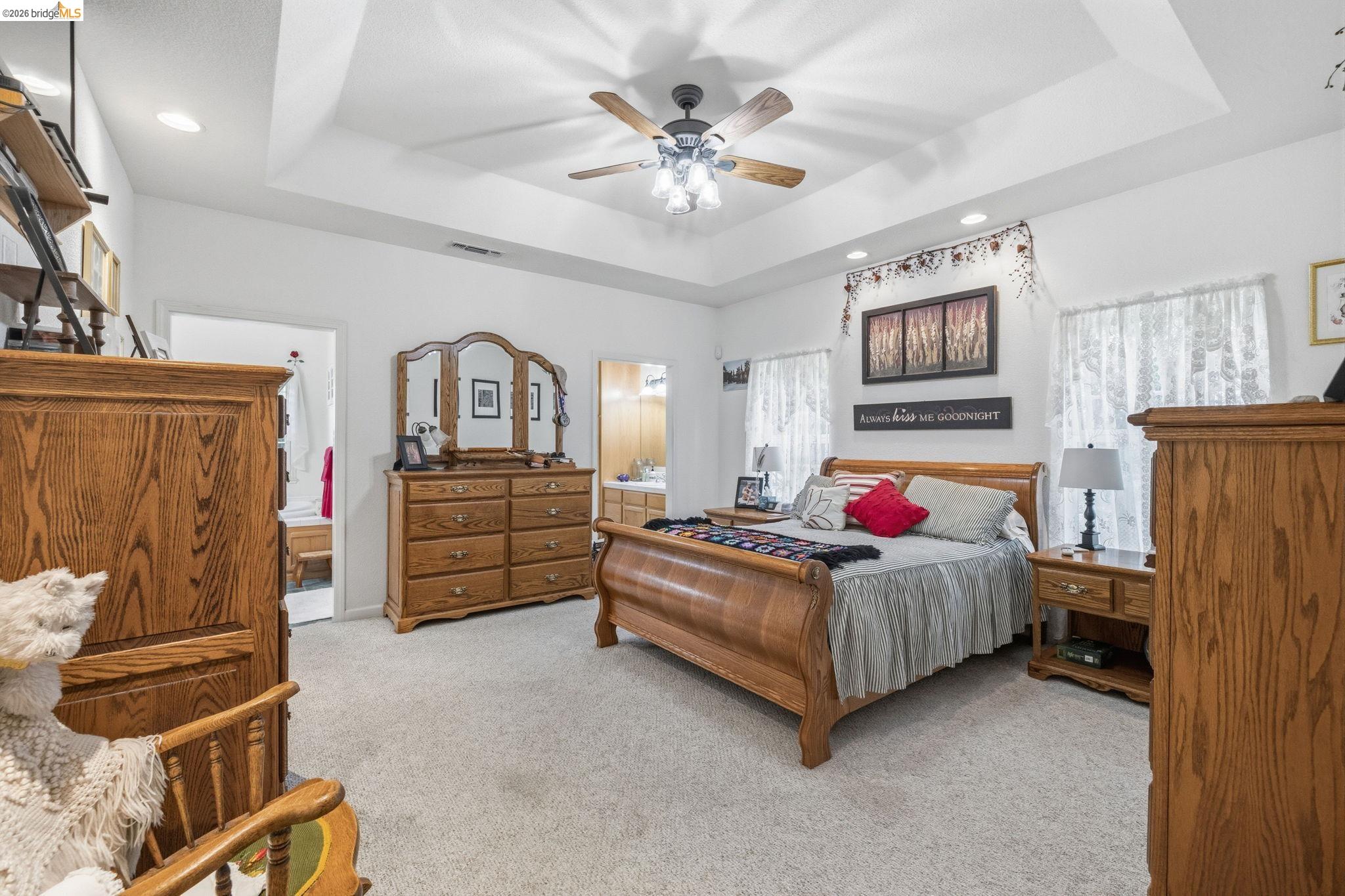 18450 Lambert Lake Road Sonora, CA 95370 - Photo 22 of 87 Spacious room featuring a tray ceiling with a ceiling fan, recessed lighting, carpet flooring, and multiple windows