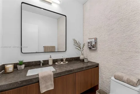 a bathroom with a granite countertop sink and a mirror