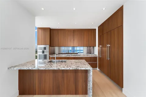 a view of kitchen island cabinets and refrigerator