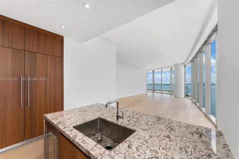 a kitchen with a sink a counter top space and cabinets