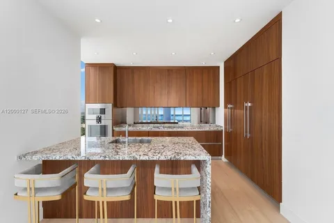 a kitchen with kitchen island granite countertop wooden cabinets and a counter top space