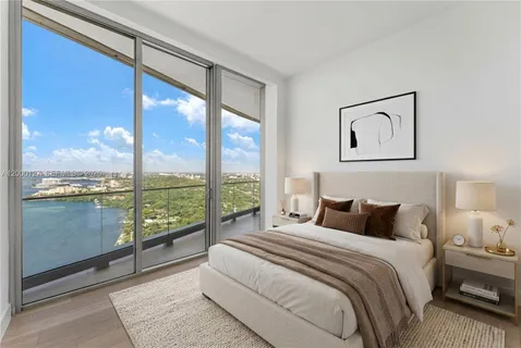 a bedroom with a large window and a bed