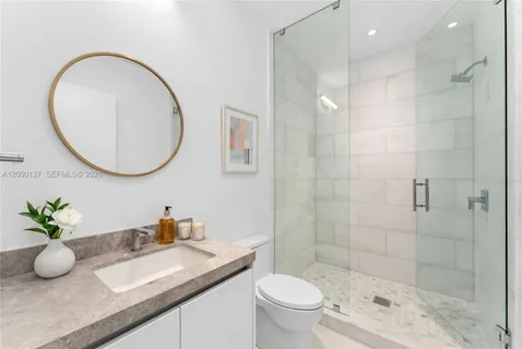 a bathroom with a granite countertop sink a toilet and a mirror