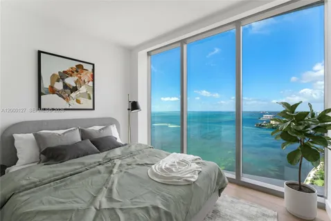 a bedroom with a balcony a bed and a potted plant