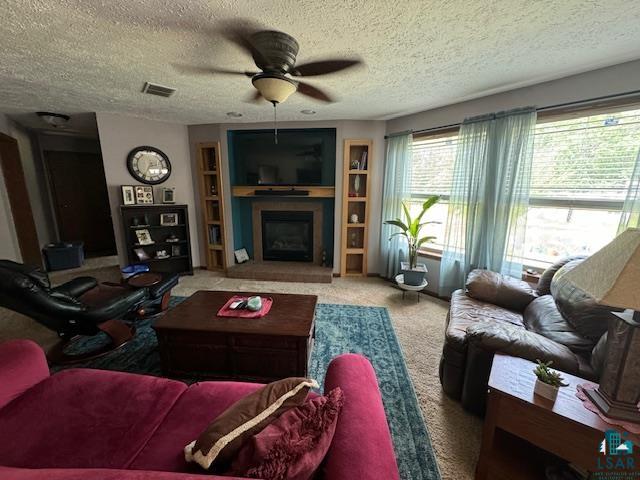 9015 Arkola Road Cotton, MN 55724 - Photo 3 of 21 Living room with built in features, a textured ceiling, carpet, and ceiling fan