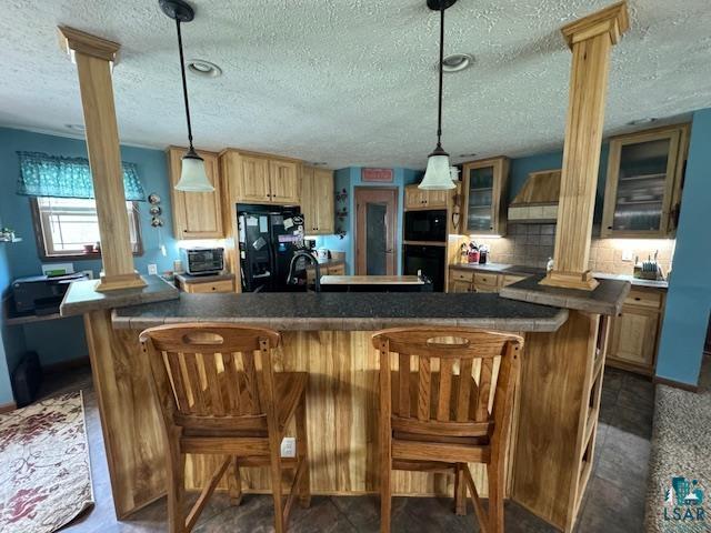 9015 Arkola Road Cotton, MN 55724 - Photo 4 of 21 Kitchen with ornate columns, black appliances, and wall chimney range hood