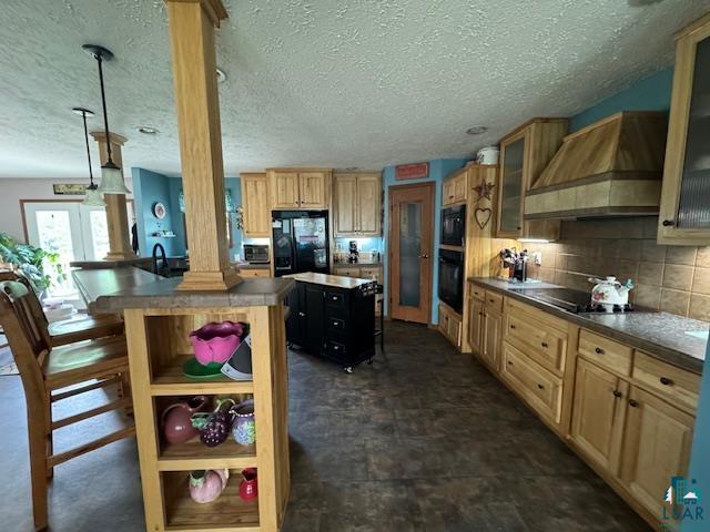9015 Arkola Road Cotton, MN 55724 - Photo 7 of 21 Kitchen featuring custom range hood, tasteful backsplash, a center island, black appliances, and ornate columns