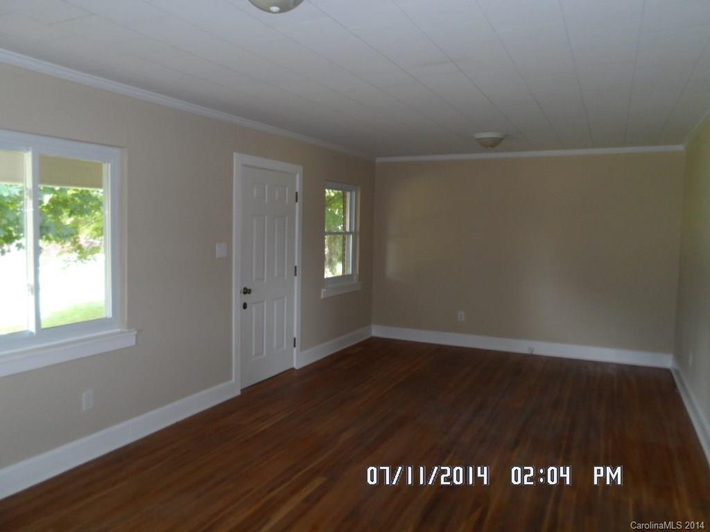 2175 Triplett Road Mooresville, NC 28115 - Photo 2 of 6 an empty room with wooden floor and windows
