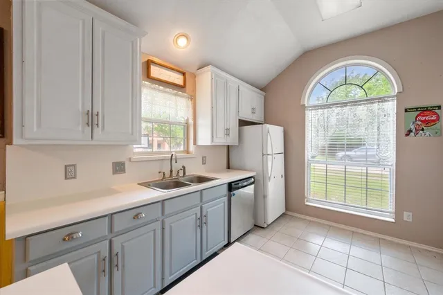 a kitchen with a sink a window and cabinets