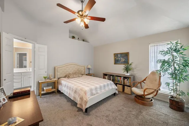 a bedroom with a bed a couch and potted plant
