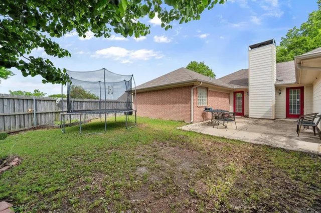 a backyard of a house with table and chairs