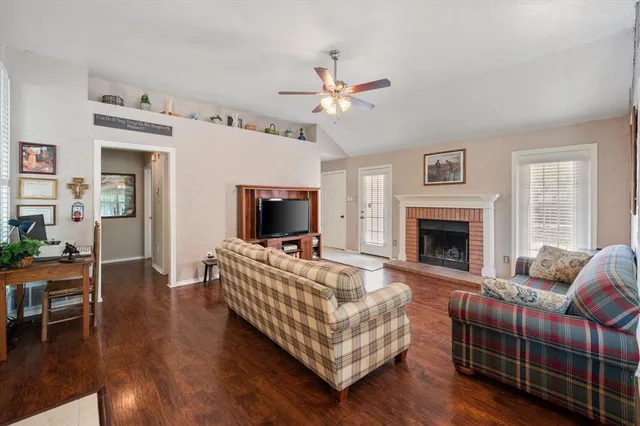 a living room with furniture a flat screen tv and a fireplace