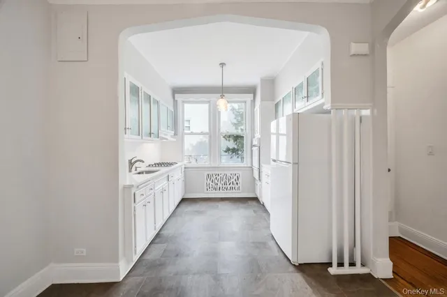 a kitchen with granite countertop white cabinets and white appliances