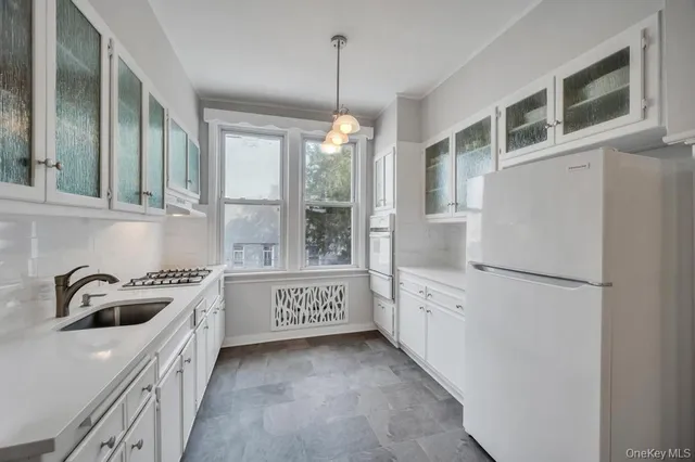 a kitchen with granite countertop a refrigerator and a sink