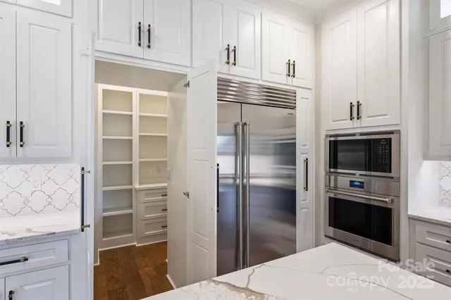 a spacious bathroom with double vanity sinks a toilet a mirror and shower