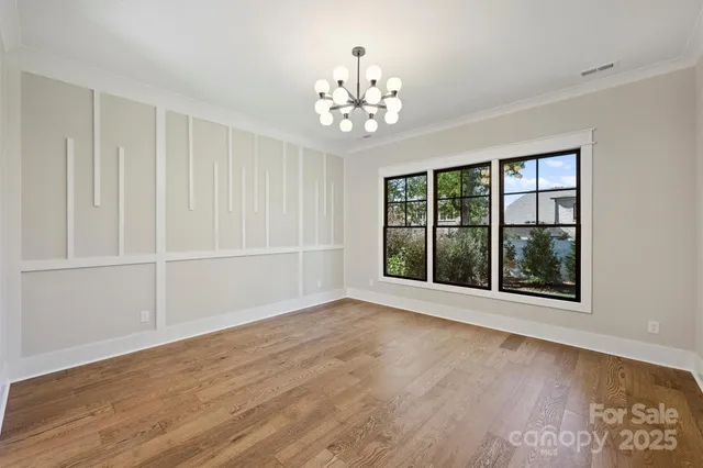 a view of a hallway with a glass door and chandelier fan