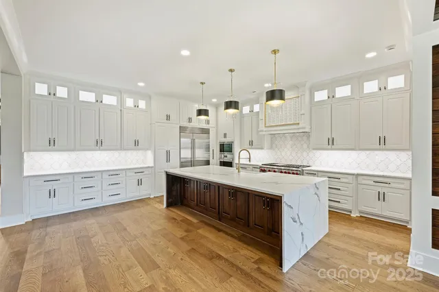 a view of a big room with wooden floor windows and a chandelier