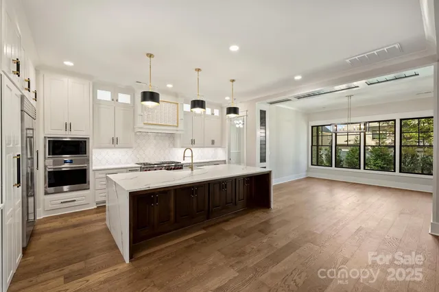 a kitchen with stainless steel appliances cabinets a island and a ceiling fan
