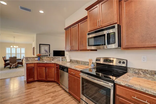 a kitchen with stainless steel appliances a stove sink microwave and cabinets
