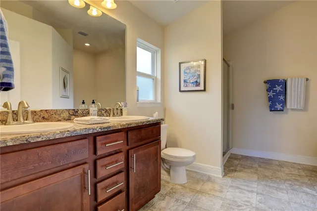 a bathroom with a granite countertop sink toilet and a mirror