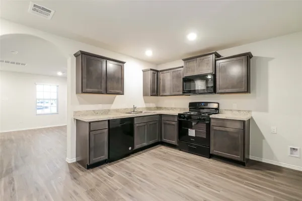 a kitchen with granite countertop a stove top oven and sink
