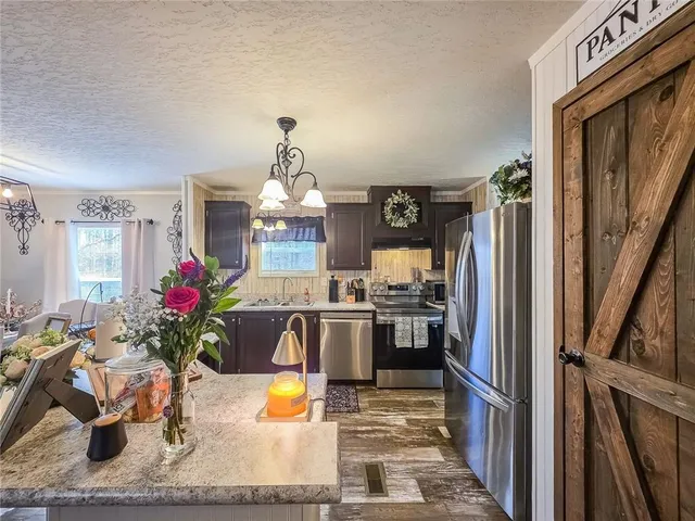 a kitchen with a refrigerator and potted plant