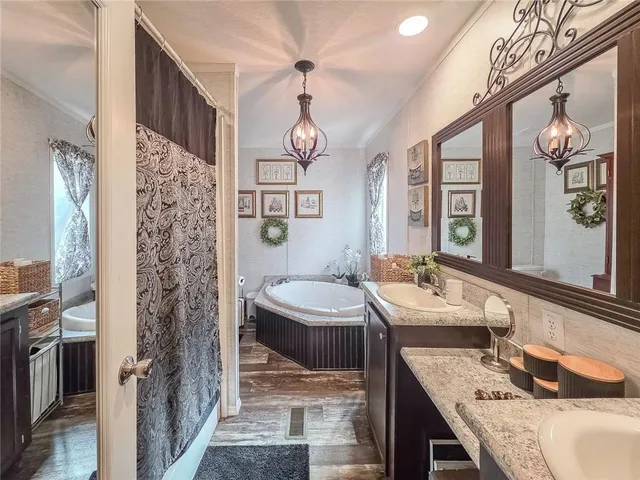 a bathroom with a granite countertop sink a toilet a mirror and shower