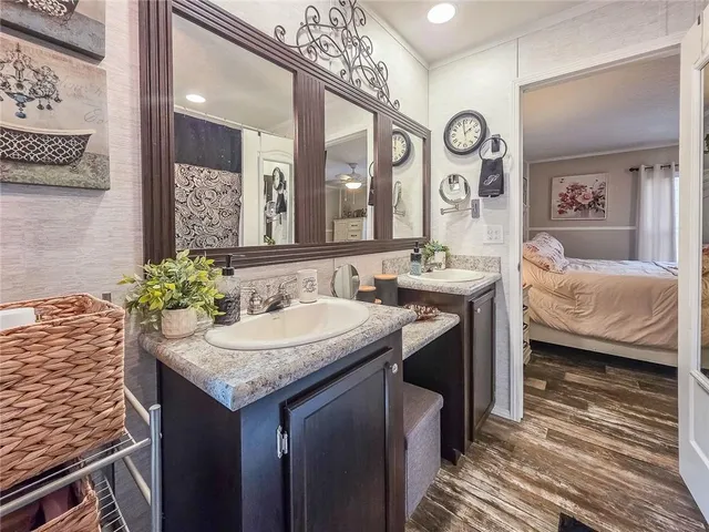 a en suite bathroom with a granite countertop sink and a mirror