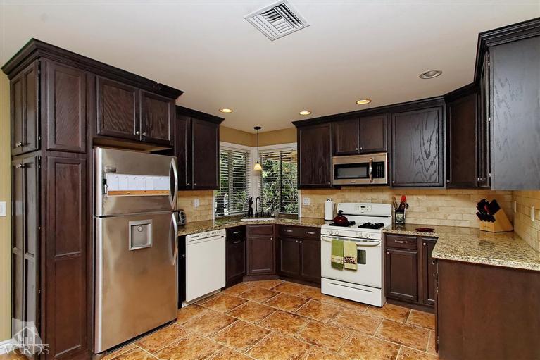 888 Appleton Road Simi Valley, CA 93065 - Photo 18 of 30 a kitchen with stainless steel appliances granite countertop a stove top oven a sink dishwasher a refrigerator and cabinets with wooden floor
