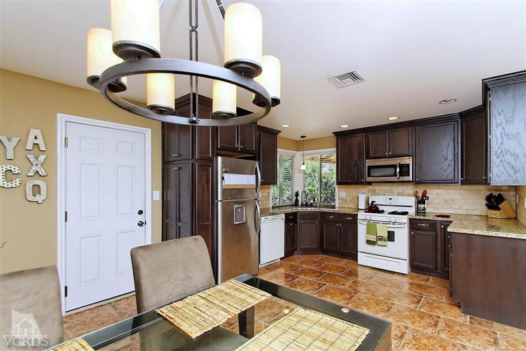 888 Appleton Road Simi Valley, CA 93065 - Photo 6 of 30 a kitchen with stainless steel appliances granite countertop a stove top oven a sink a dining table and chairs with wooden floor