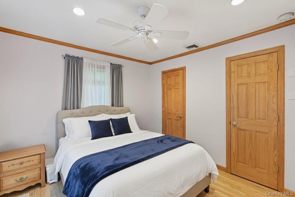 5 Liberty Street Hampton Bays, NY 11946 - Photo 13 of 17 a bedroom with a large bed and a chandelier