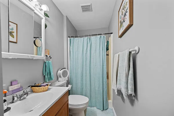 a bathroom with a toilet sink vanity and mirror