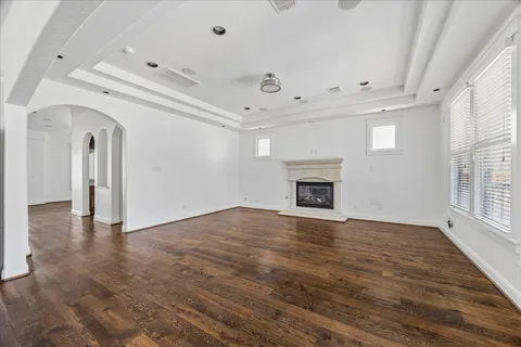 an empty room with wooden floor and fireplace